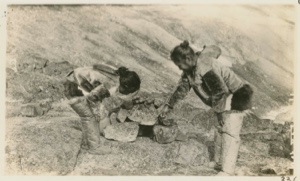Image: Mother showing daughter how to set a stone fox-trap